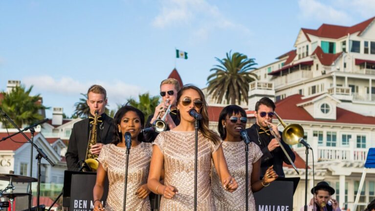 A vibrant performance by a 20-piece wedding band featuring talented singers and musicians on stage at Hotel Del Coronado, showcasing Ben Mallare Events & Entertainment's exceptional live wedding bands. The image captures the energy and elegance of a wedding celebration, emphasizing the importance of live music in creating unforgettable moments.