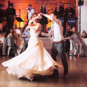 A bride and groom share a romantic first dance at their wedding reception, with a 20-piece live wedding band from Ben Mallare Events & Entertainment performing in the background, creating an unforgettable atmosphere.