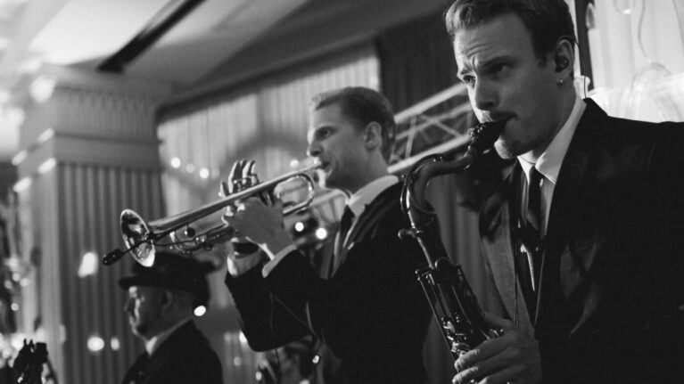 Live wedding band musicians performing on stage, featuring trumpet and saxophone players from Ben Mallare Events & Entertainment.