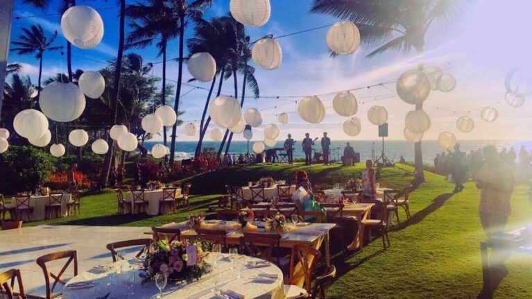 Outdoor wedding reception setup at Andaz Maui with elegant table settings and hanging lanterns, perfect for a live wedding band performance. Ideal venue for Ben Mallare Events & Entertainment to provide a 20-piece wedding band for an unforgettable celebration.