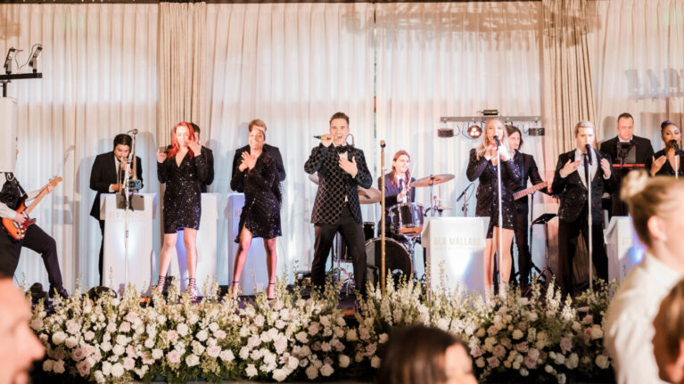 A 20-piece wedding band from Ben Mallare Events & Entertainment performing live on stage, featuring vocalists and musicians, creating an energetic and memorable wedding reception atmosphere. A 20-piece wedding band from Ben Mallare Events & Entertainment performing live on stage, featuring vocalists and musicians, creating an energetic and memorable wedding reception atmosphere.