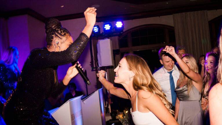 A lively wedding reception with a singer from Ben Mallare Events & Entertainment engaging with guests, showcasing the energy of live wedding bands.