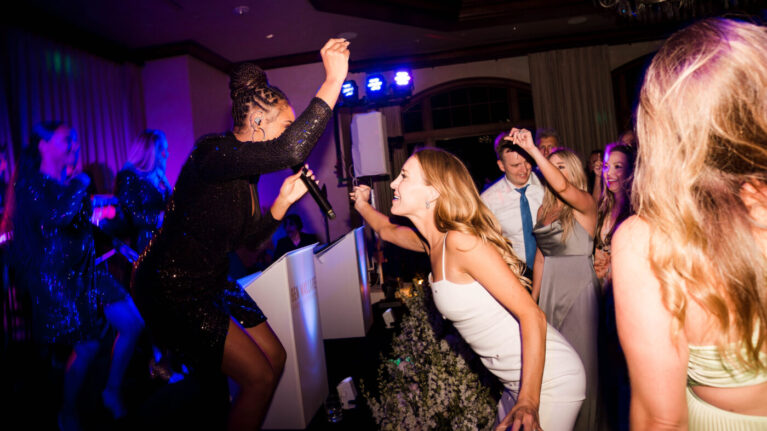 Live wedding band singer from Ben Mallare Events & Entertainment performing on stage with guests dancing and celebrating at a wedding reception.