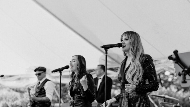 Live wedding band performing on stage with multiple musicians, featuring vocalists and instrumentalists from Ben Mallare Events & Entertainment.