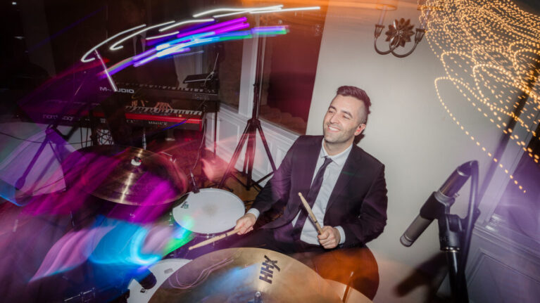 Drummer from Ben Mallare Events & Entertainment performing live at a wedding reception, showcasing the energy and excitement of live wedding bands.