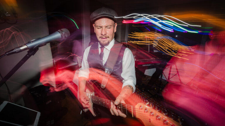 A musician from Ben Mallare Events & Entertainment playing the guitar during a live wedding band performance.