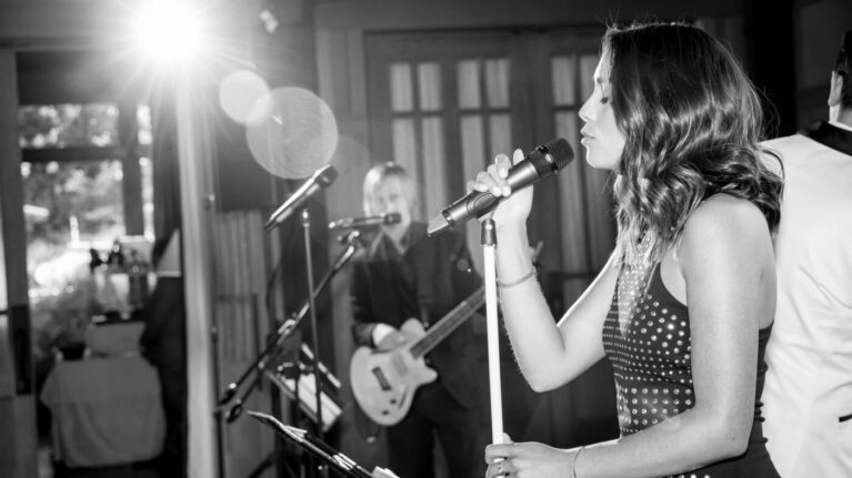 A talented singer and guitarist from a 20-piece wedding band perform live at a wedding reception, showcasing the exceptional entertainment provided by Ben Mallare Events & Entertainment.