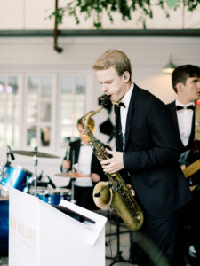 Live wedding band musicians performing on stage, featuring a saxophonist and other instrumentalists, showcasing Ben Mallare Events & Entertainment's 20-piece wedding band.