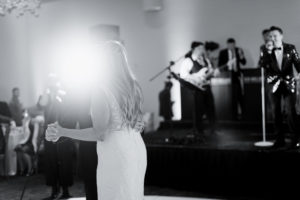 A bride and groom share their first dance while a 20-piece wedding band from Ben Mallare Events & Entertainment performs live music on stage in the background.