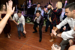 A lively 20-piece wedding band from Ben Mallare Events & Entertainment performing on stage, engaging guests on the dance floor at a wedding reception.