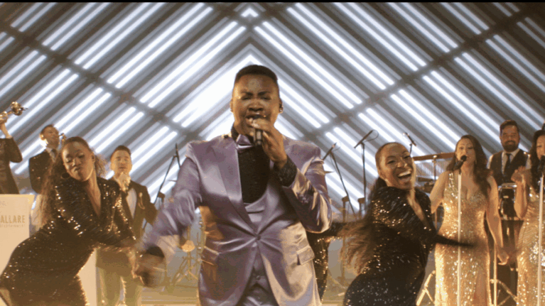 A 20-piece live wedding band from Ben Mallare Events & Entertainment performing energetically on stage, featuring a lead singer in a purple suit and backup musicians.