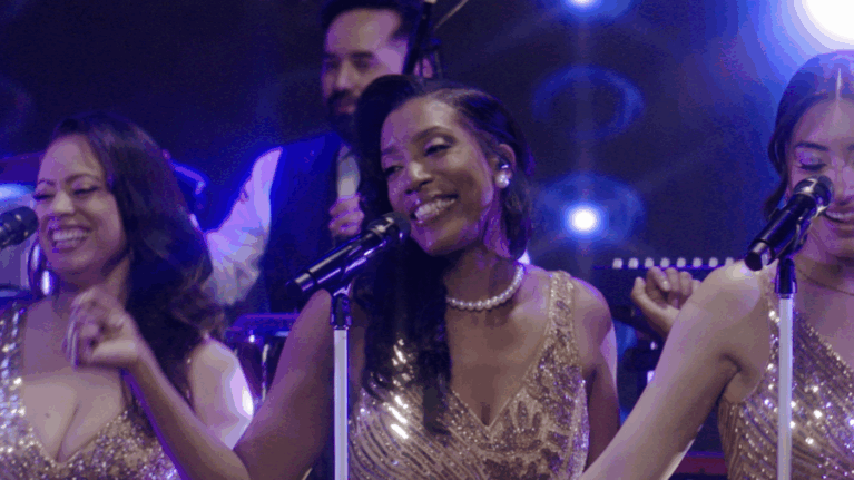 A talented singer performing with a live wedding band from Ben Mallare Events & Entertainment, featuring a vibrant stage presence and a 20-piece ensemble.